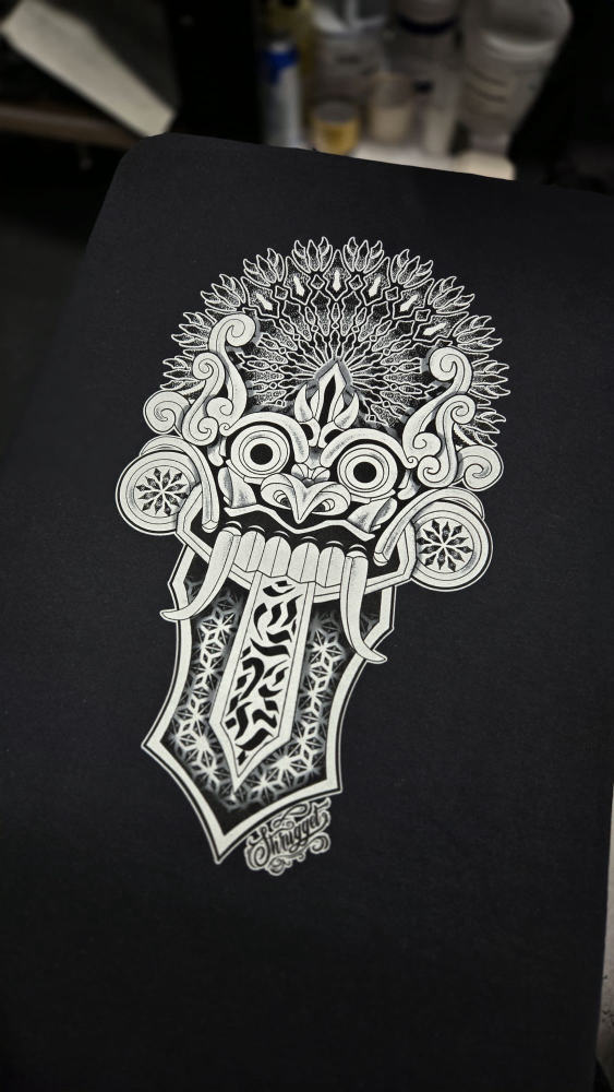 Intricate Balinese demon mask design screen printed in white ink on a black tee