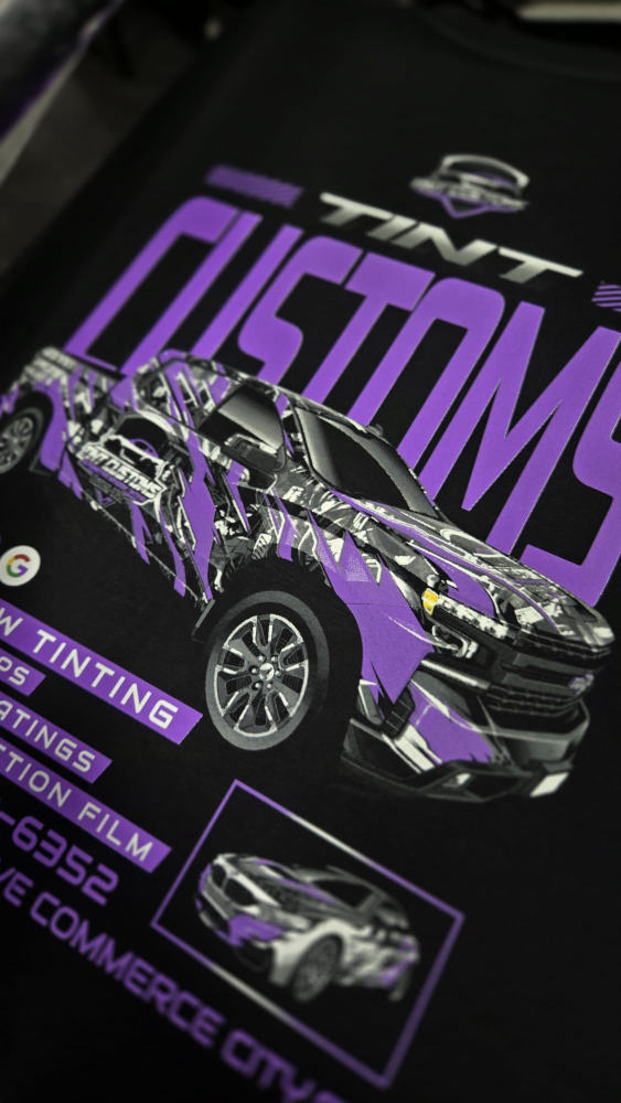 Tint Customs promo tee with a custom-wrapped truck illustration in purple